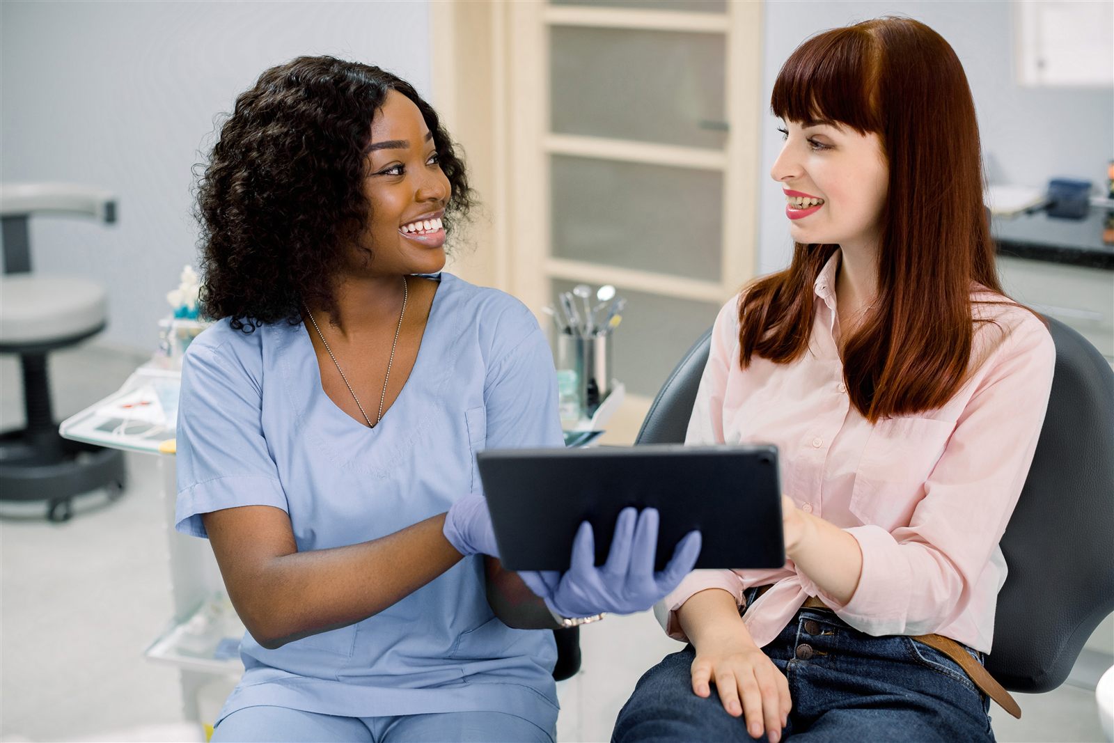 Adult patient and dental professional reviewing information on a tablet