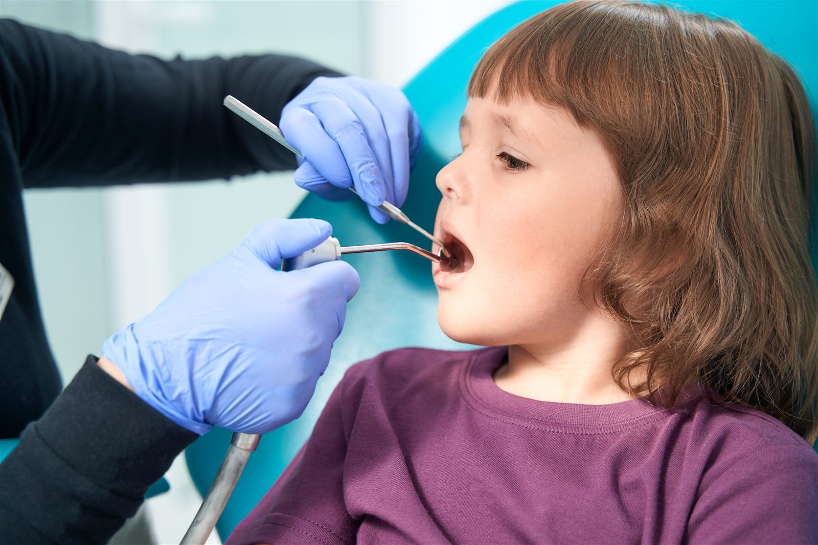Child having a dental examination with a mirror and dental instruments